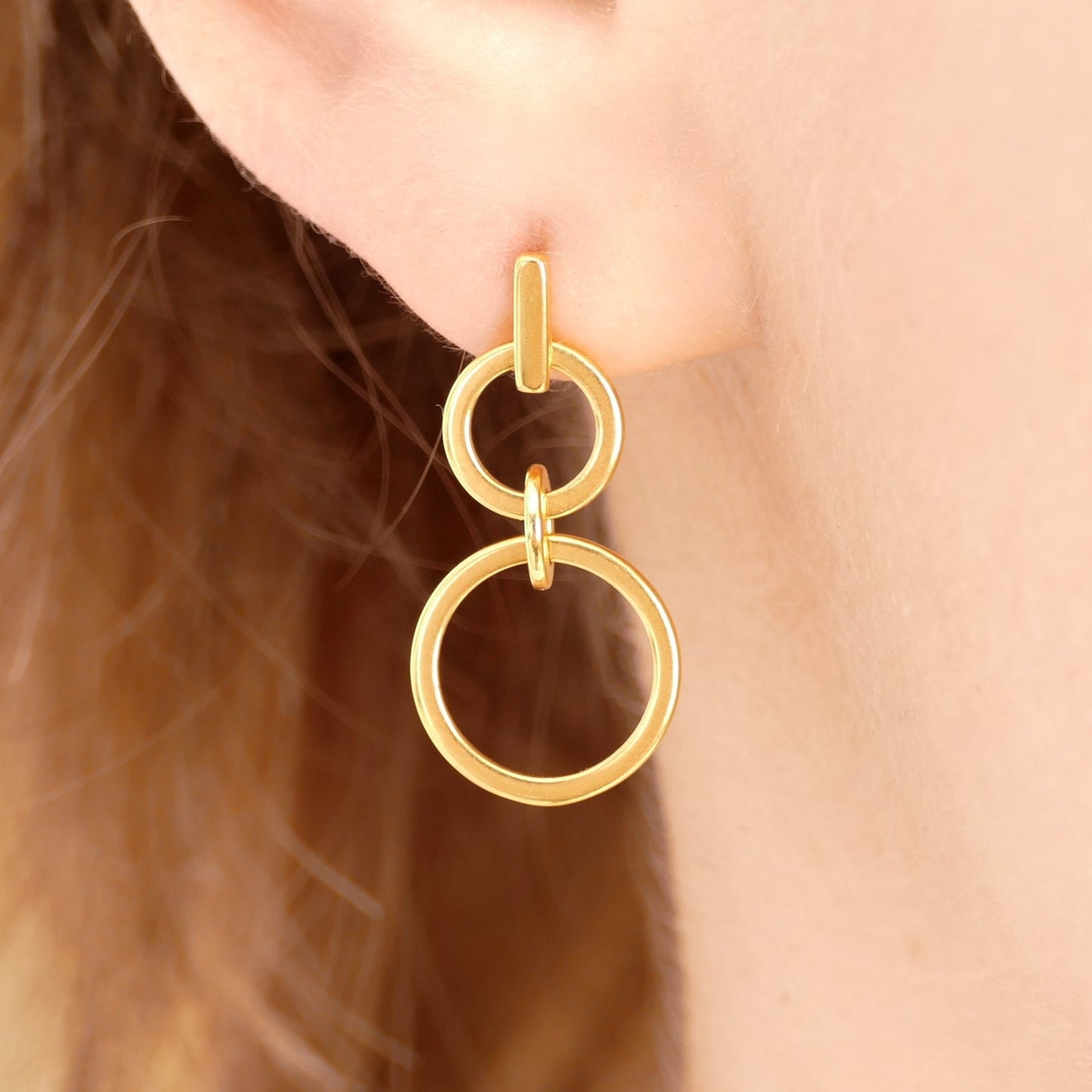 Double Circle Drop Earrings in Gold, featuring two interlocking circles with a sleek, modern geometric design